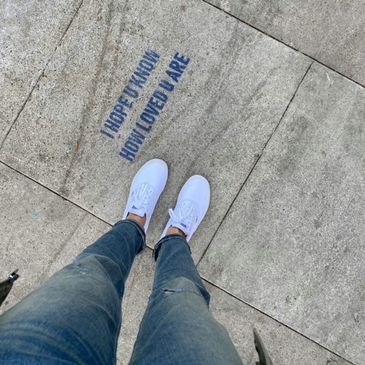 Person stehend vor hoffnungsvollem Schriftzug