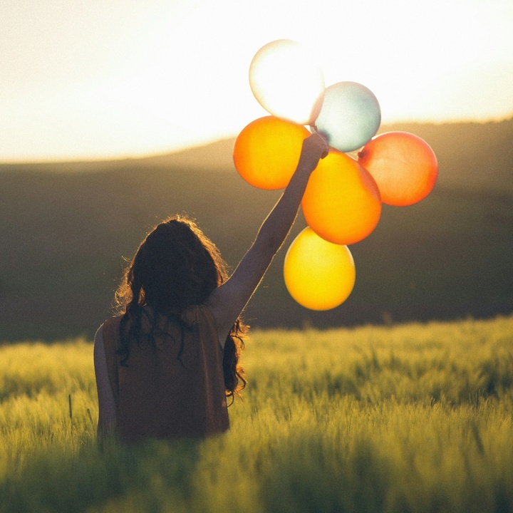Frau hält bunte Luftballons in die Höhe