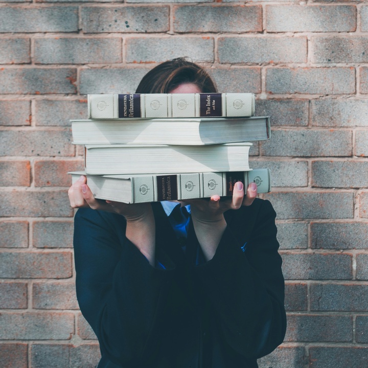 Studentin mit vielen Büchern