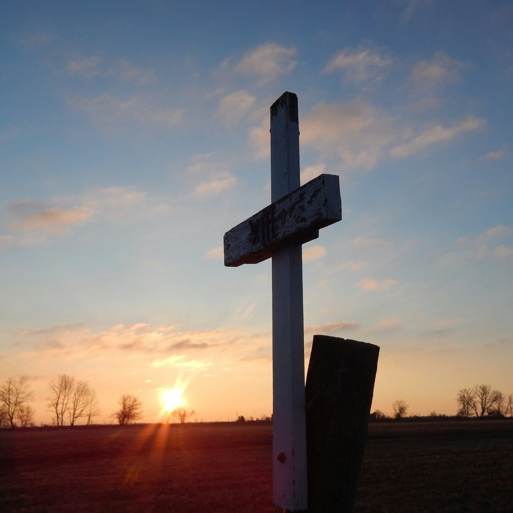 Kreuz vor aufgehender Sonne