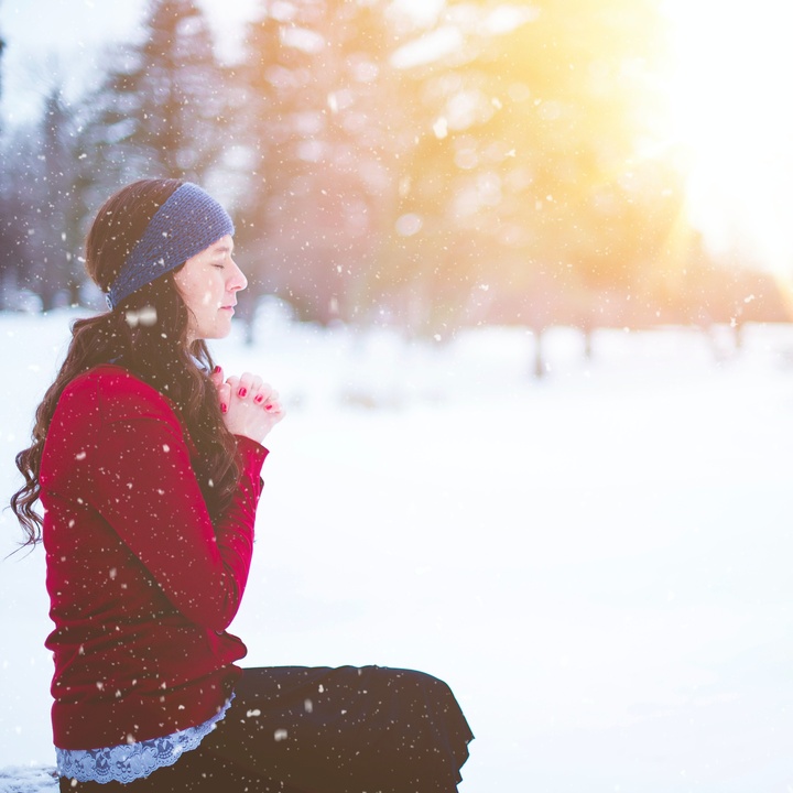 Frau betend im Schnee